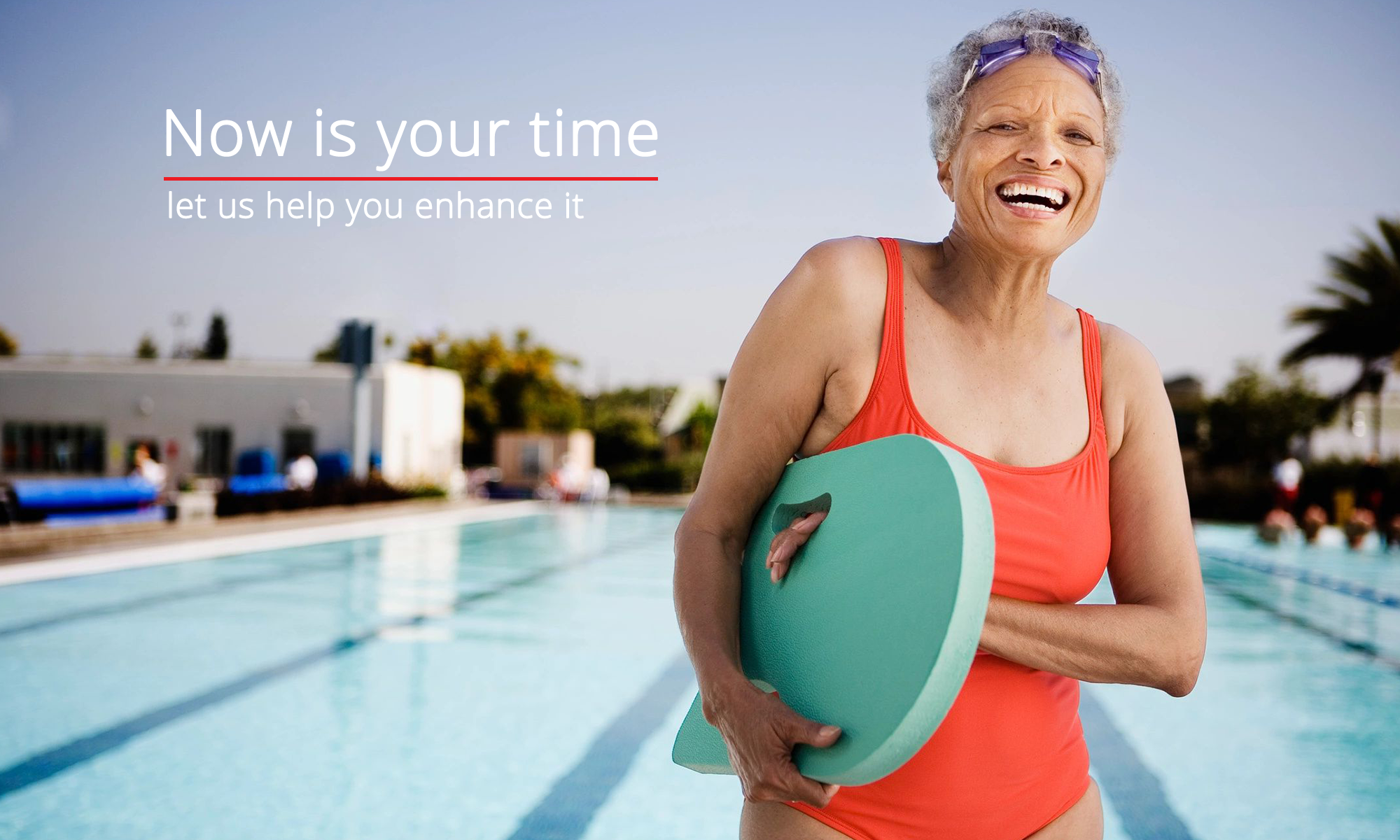 Elderly woman in a swimsuit and goggles in front of a swimming pool with lanes