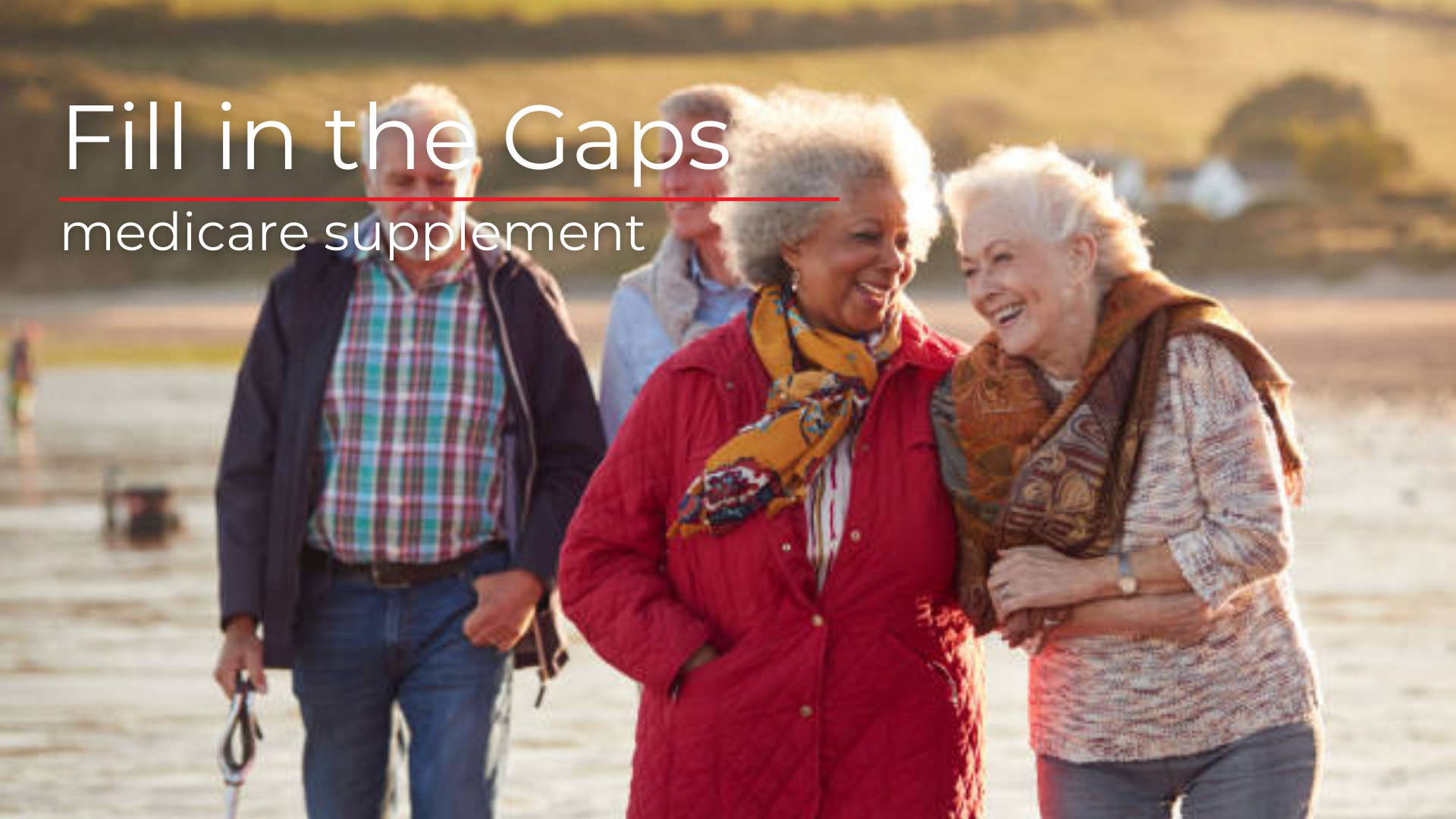 Group of 4 seniors walking, arm in arm, along a beach